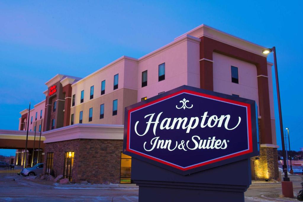 um sinal fora de uma estalagem e suites de Hampton em Hampton Inn & Suites Bismarck Northwest em Bismarck