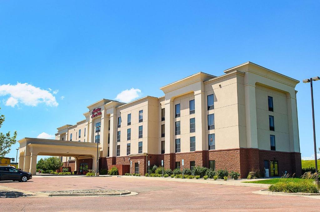 a large building with a car parked in front of it at Hampton Inn & Suites Brookings in Brookings