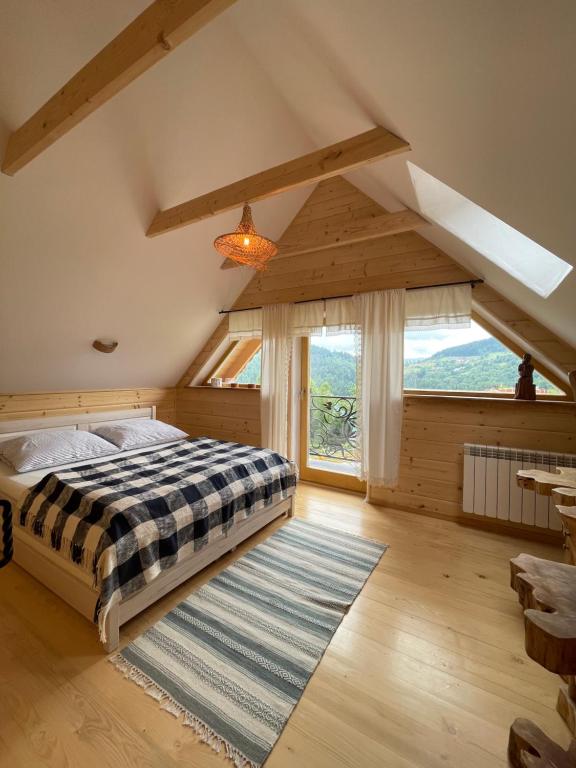 a bedroom with a bed and a large window at Gliniana Chata in Zawoja