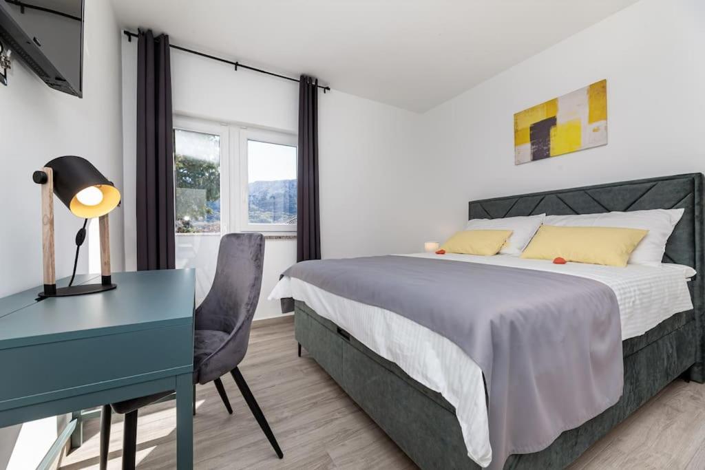 a bedroom with a bed and a desk and a table and chair at Apartman Milazzi in Baška
