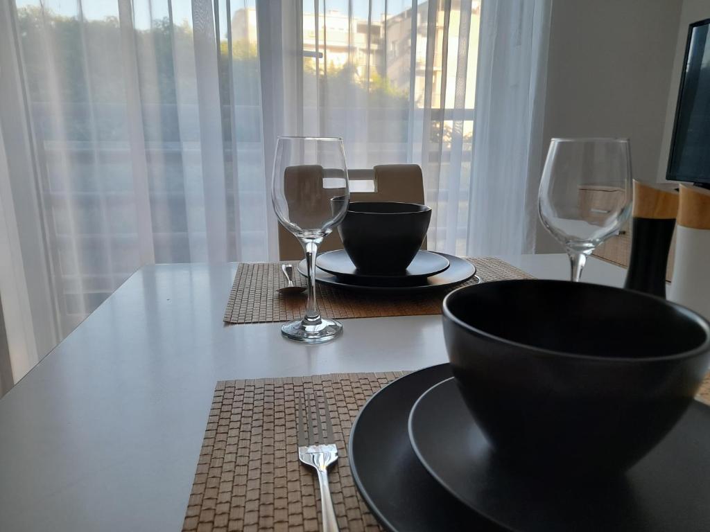 諾維薩德的住宿－Nikola NS，一张桌子,上面放着两杯酒杯,上面放着一碗