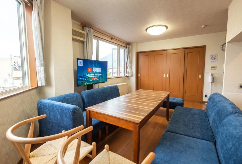 ein Wartezimmer mit einem Tisch und blauen Stühlen in der Unterkunft Ezo Fujiya Niseko House - Vacation STAY 14767 in Kutchan