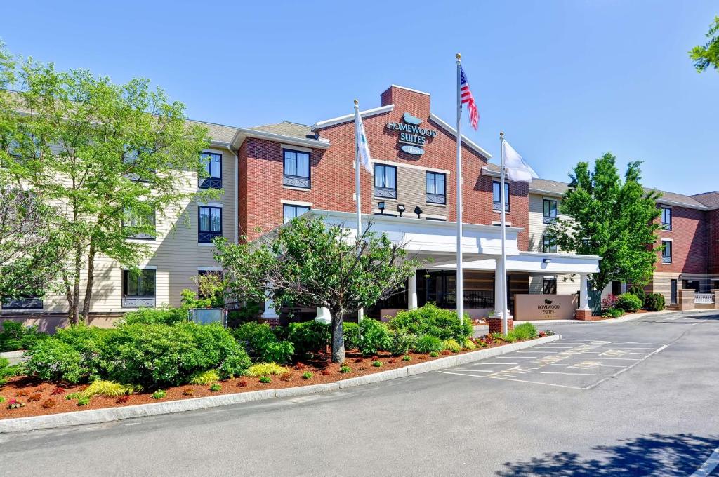 Um edifício com uma bandeira americana à frente. em Homewood Suites by Hilton Boston Cambridge-Arlington, MA em Arlington