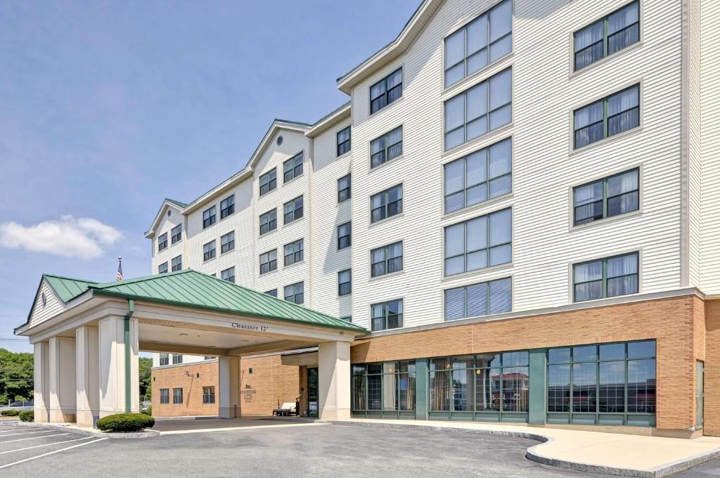 un grand bâtiment blanc avec un parking dans l'établissement Homewood Suites Boston Peabody, à Peabody