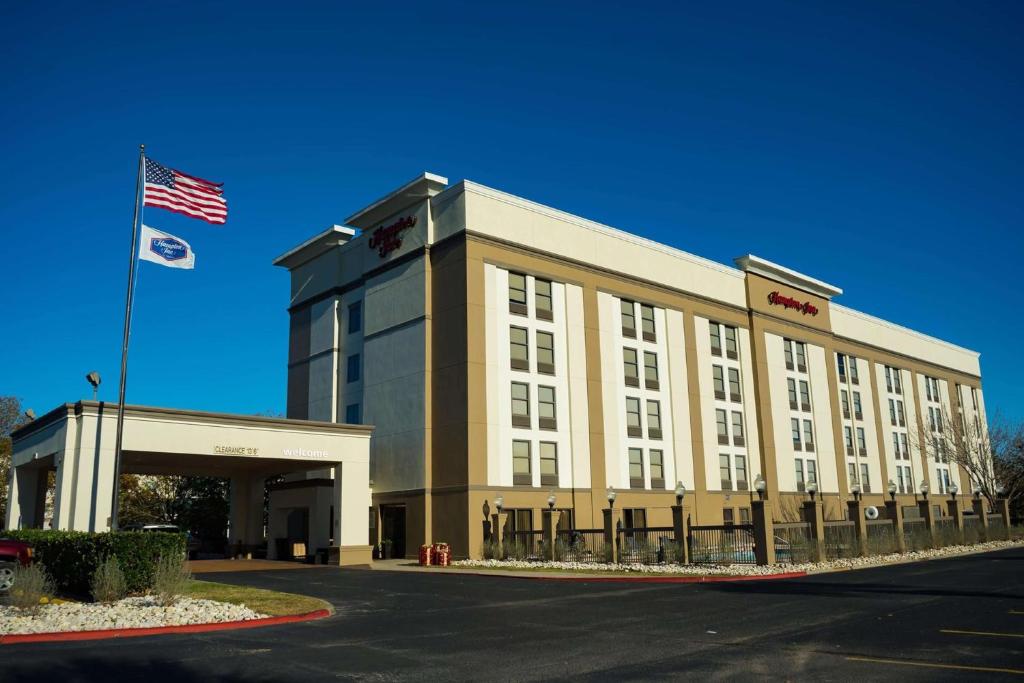 a building with an american flag in front of it at Hampton Inn Beaumont in Beaumont