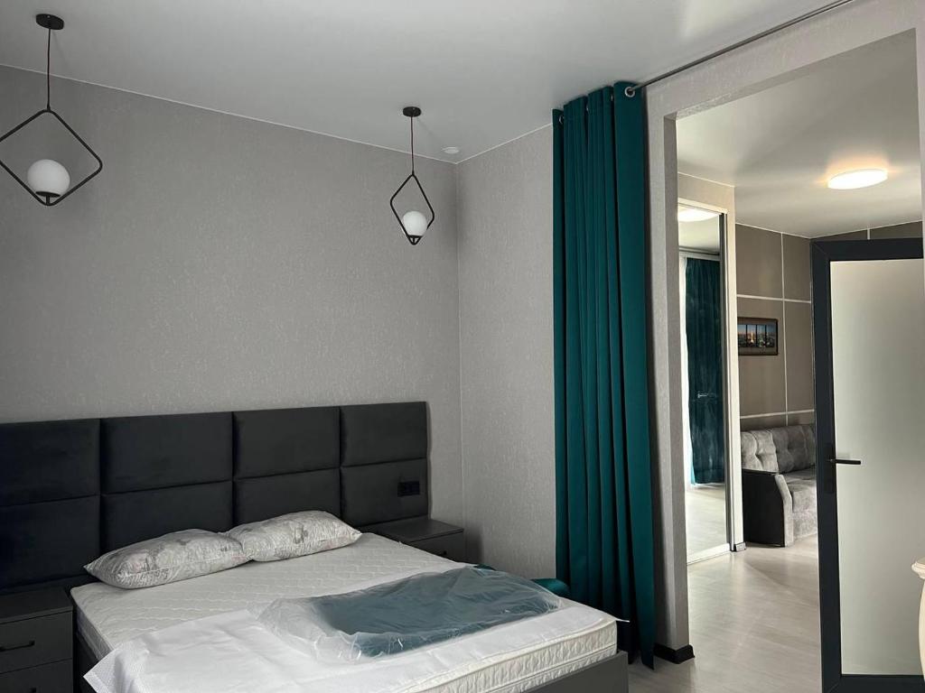 sypialnia z łóżkiem i zieloną zasłoną w obiekcie VIP HOTEL ZATOKA w Zatoce