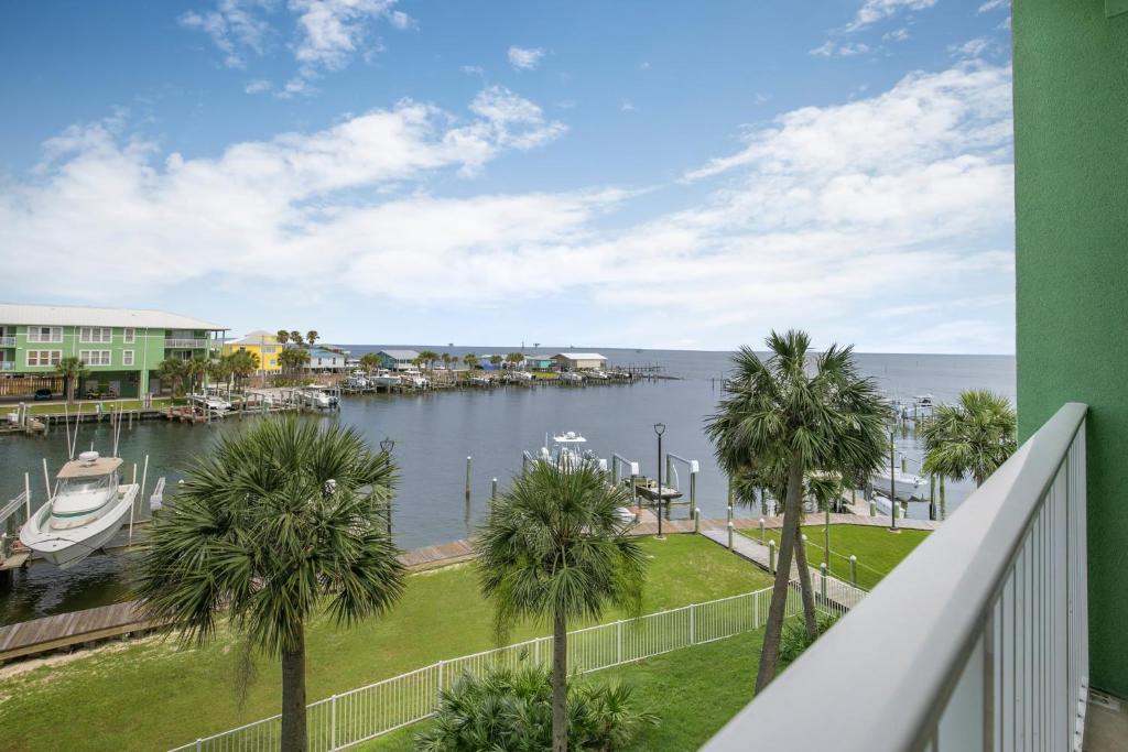 a balcony with palm trees and a marina at Navy Cove Harbor 1205 by Vacation Homes Collection in Fort Morgan