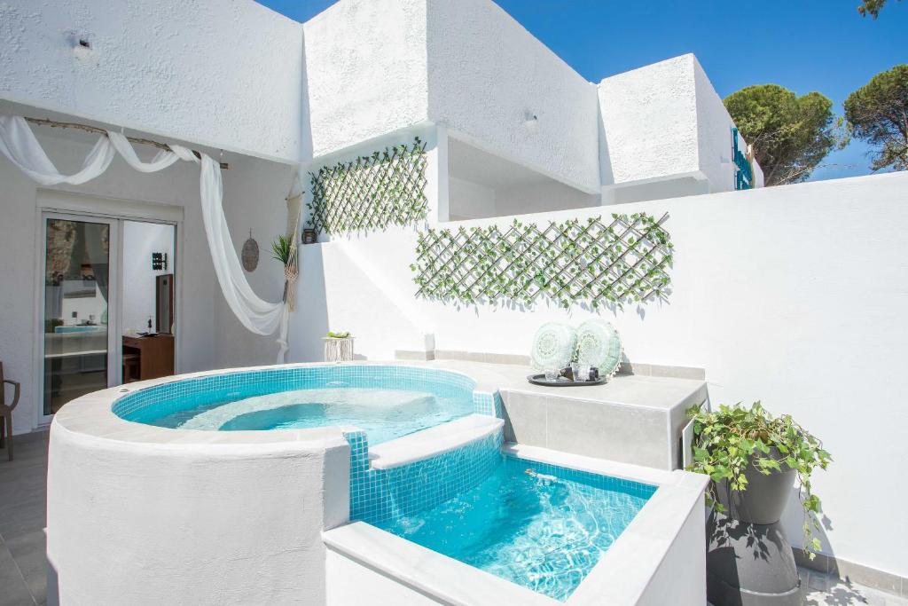 une piscine au milieu d'une maison blanche dans l'établissement CASA MIKELE by Sarikas Anthony Quinn Beach Faliraki - Ladikos Garden, à Faliraki