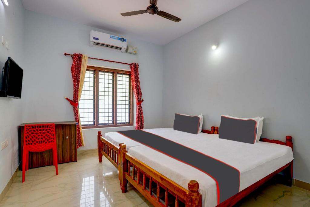 een slaapkamer met een groot bed in een kamer bij OYO B&B Rooms in Kollam