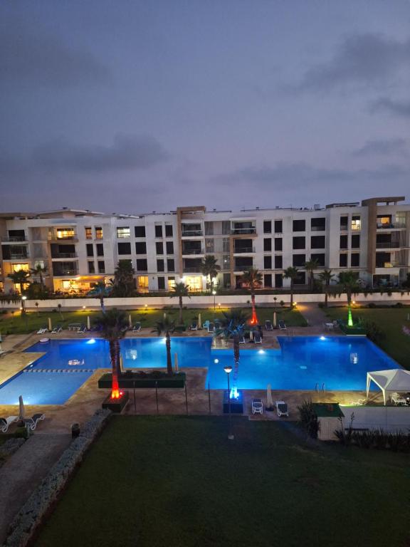 widok na basen hotelowy w nocy w obiekcie prestigia plage des nation w mieście Sidi Bouqnadel