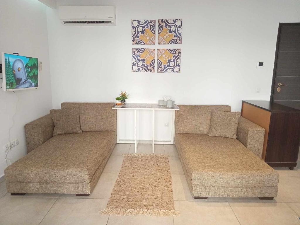a living room with two couches and a table at Studio du Lagon de Hammamet in Nabeul