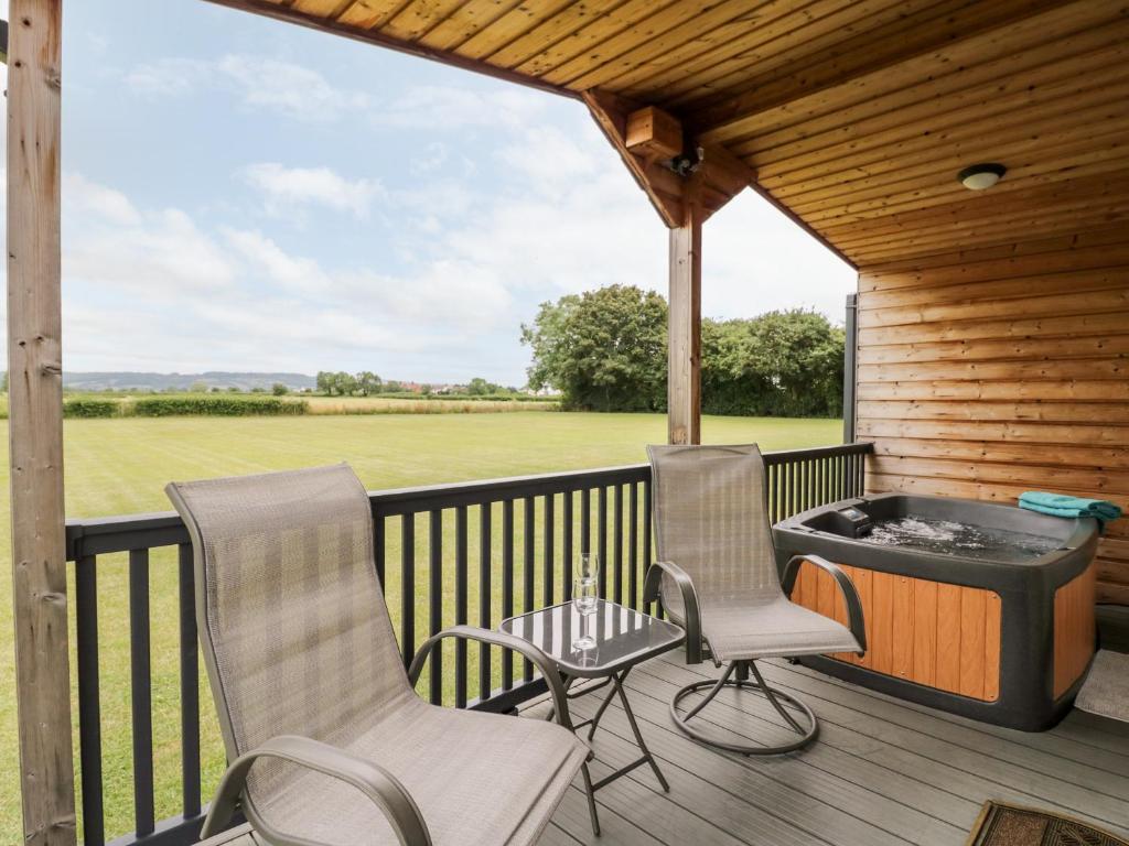 two chairs and a hot tub on a deck at Cotswold View 4 in Evesham