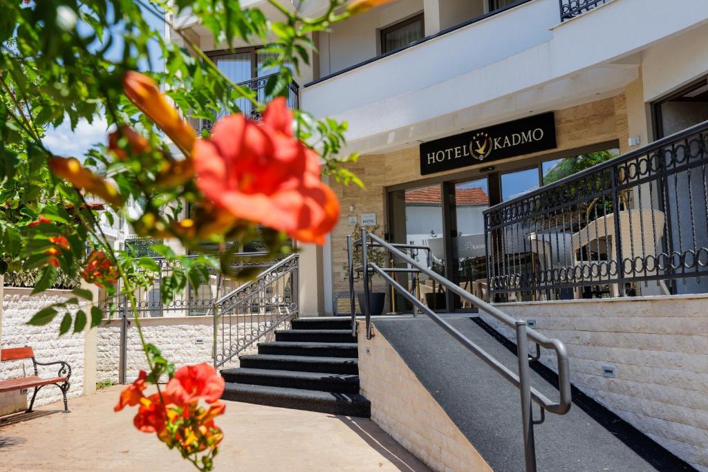 un bâtiment avec des escaliers et une fleur rouge dans l'établissement Hotel Kadmo by Aycon, à Budva