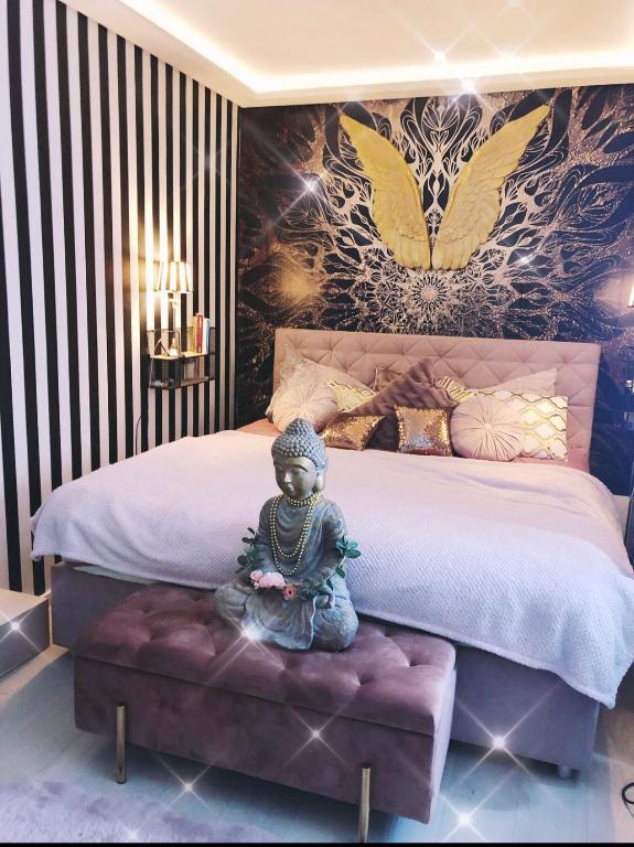 a statue sitting on a bench in a bedroom at Idyllisches Nest über den Dächern in Dortmund