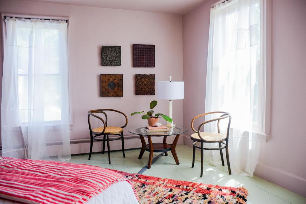WaldoboroにあるThe Waldoboro Inn Room 5のテーブルと椅子とベッドのある寝室