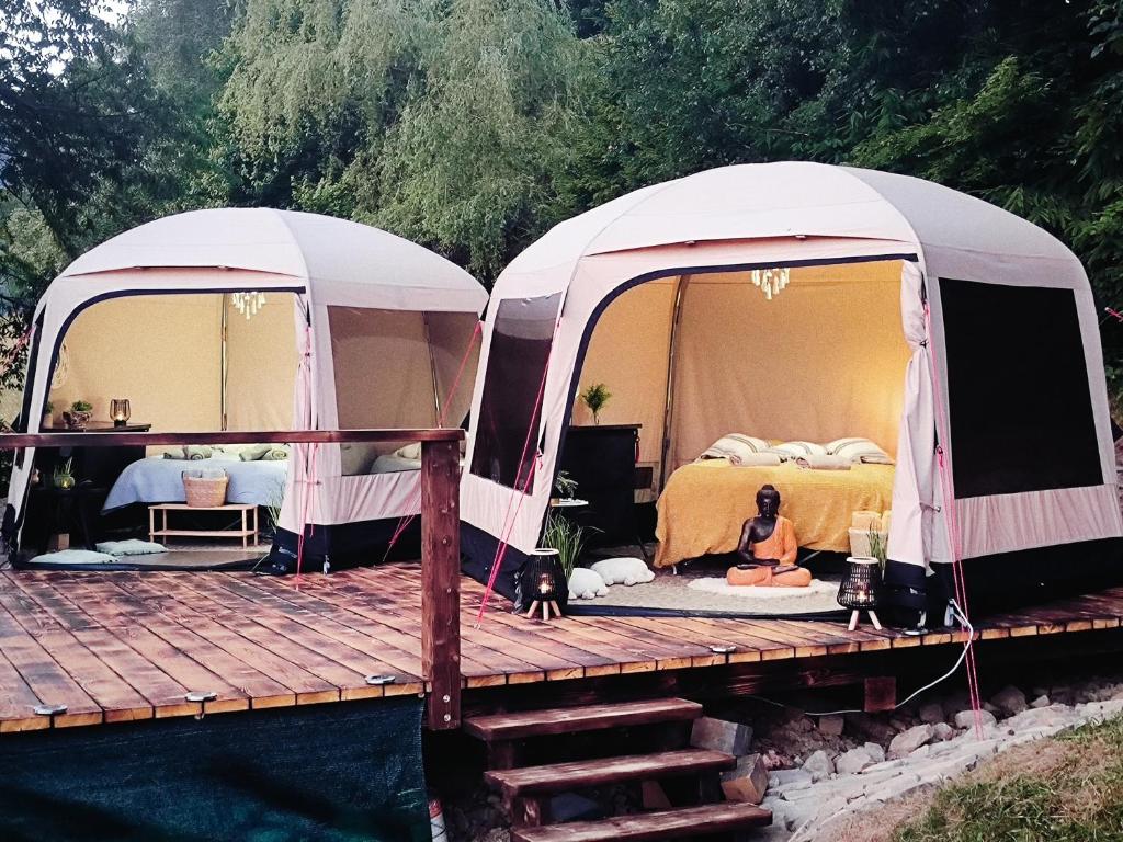 2 Zelte mit einer Frau auf einem Holzdeck in der Unterkunft Glamping Rožnov in Rožnov pod Radhoštěm
