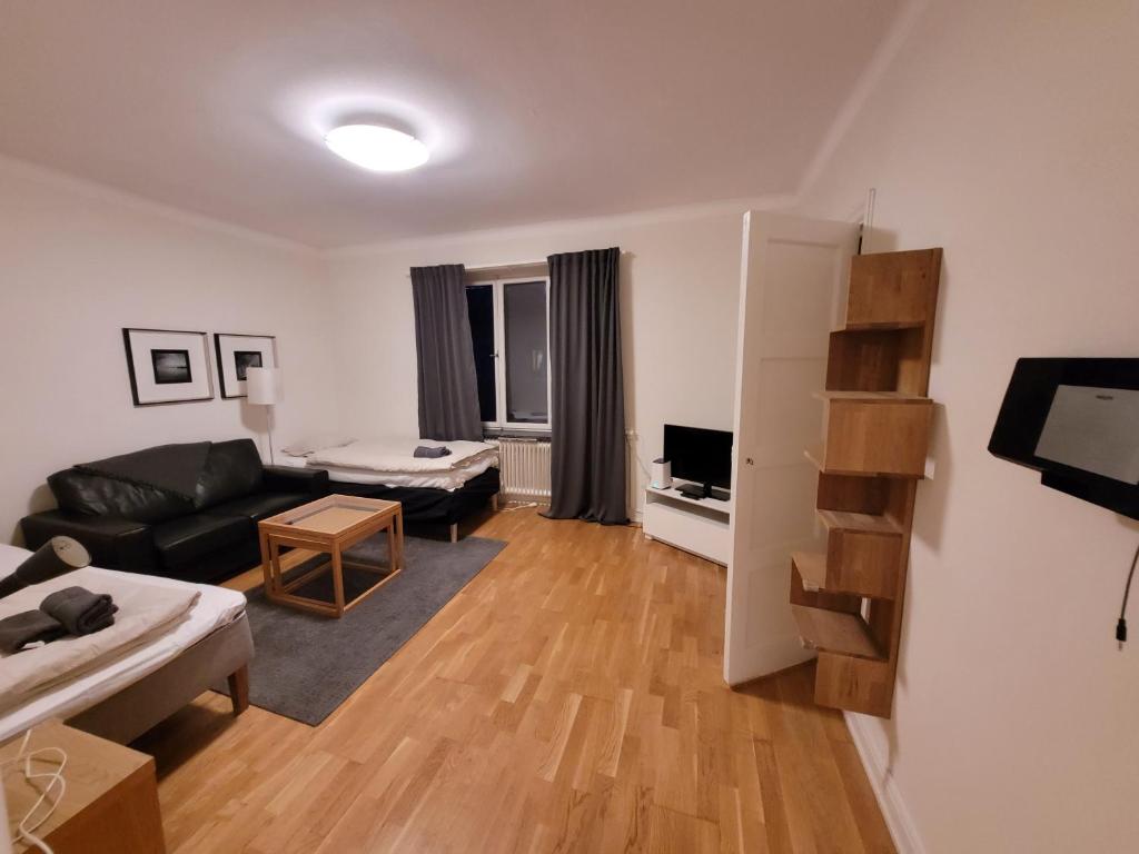 een woonkamer met een zwarte bank en een tafel bij Home Inn BG11 in Stockholm