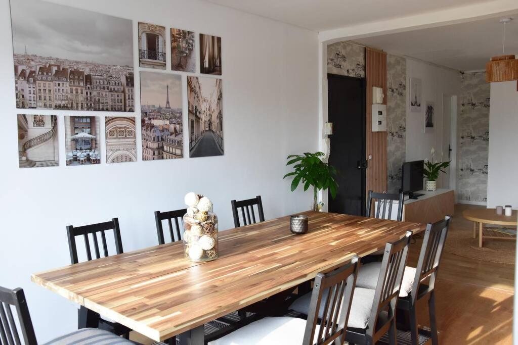 comedor con mesa de madera y sillas en Appartement 4 Chambres en Champigny-sur-Marne