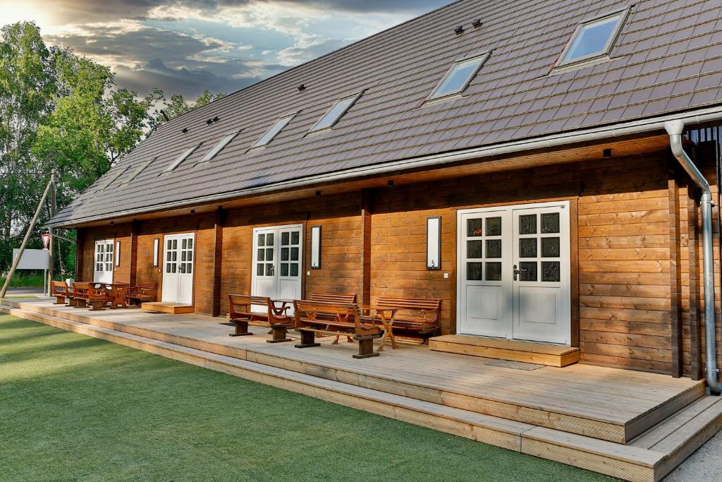 a wooden cabin with benches on a deck at Ferienwohnungen an der Hauptspree in Kolonie