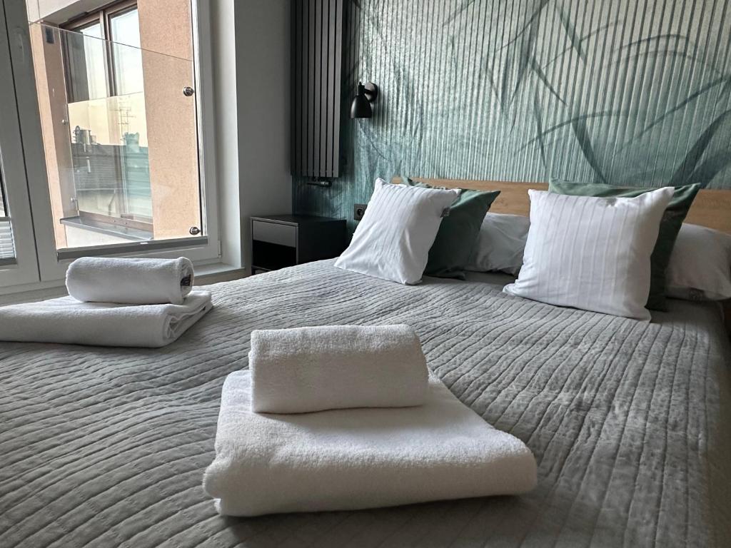 a large white bed with two white pillows on it at Verona House Apartment in Krakow