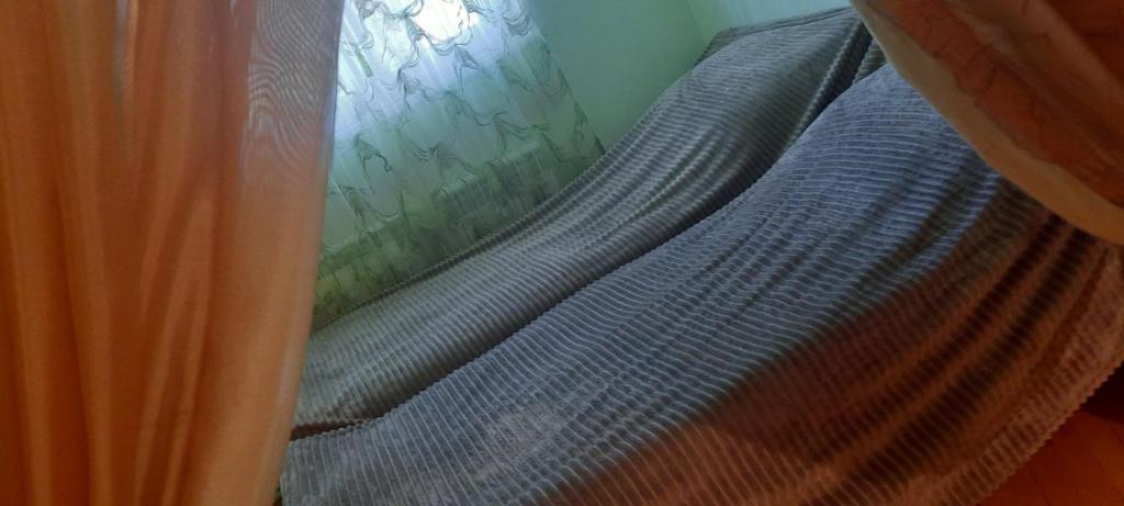 a blue bed with a curtain next to a window at Cozy apartment in Sevan City in Sevan