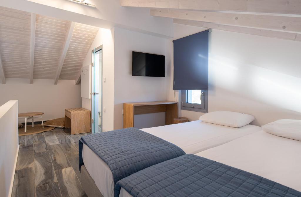 a bedroom with a bed and a tv on the wall at Notia Luxury Living in Porto Koufo