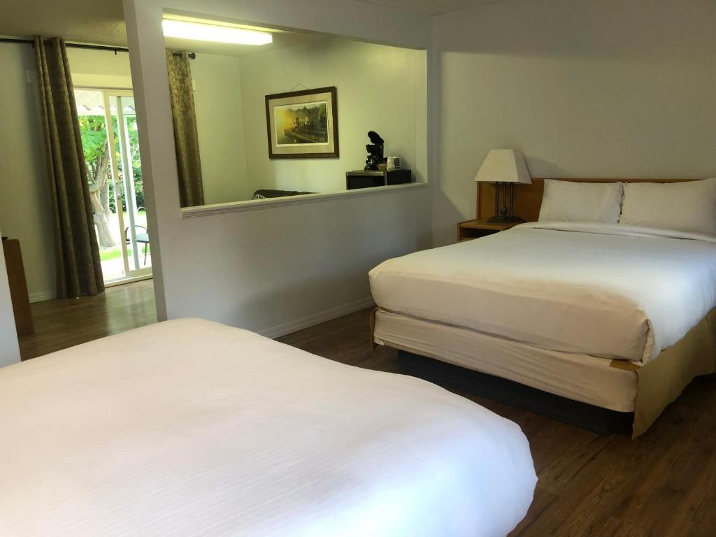 Cette chambre comprend 2 lits et une fenêtre. dans l'établissement Bavarian Orchard Motel, à Creston