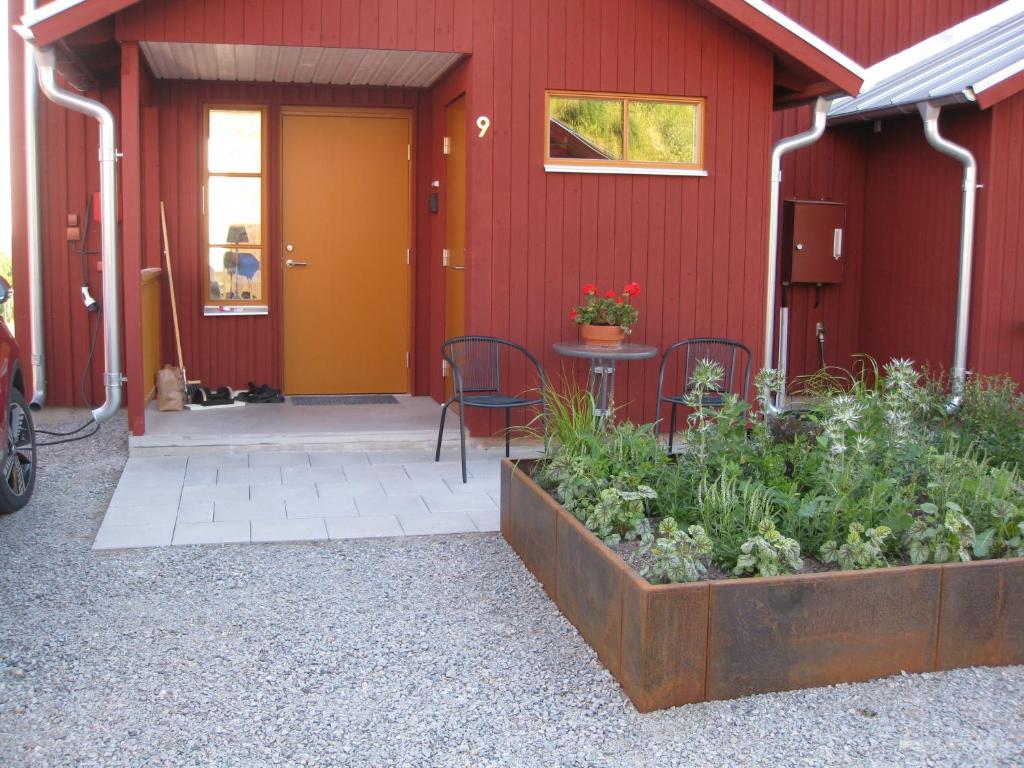 a red building with a table and chairs in front of it at Tällberg, utsikt över Siljan in Leksand