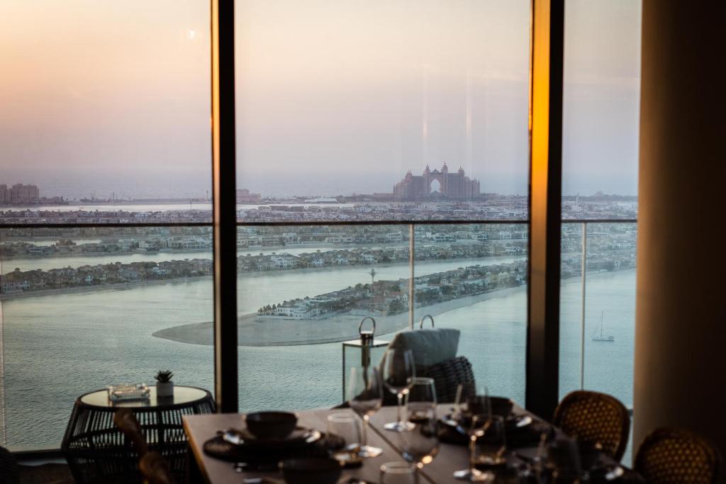 a dining room with a view of the ocean at Luxury Penthouse I 220 deg View of the Palm I Dubai Harbour I Private Beach in Dubai