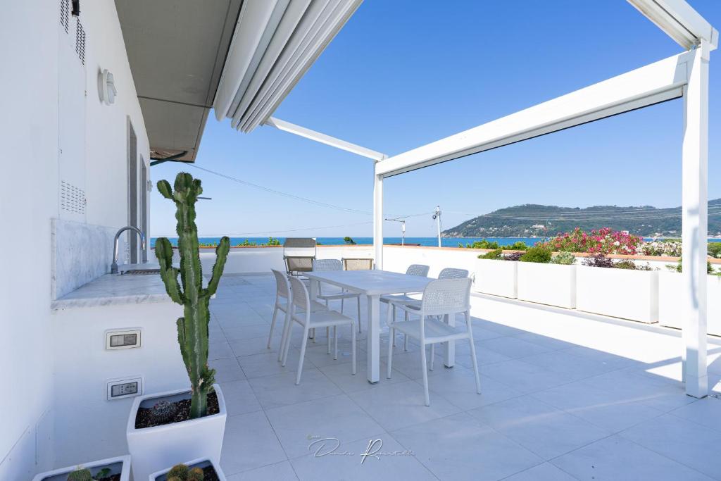 een tafel en stoelen op een balkon met uitzicht op de oceaan bij Casa vacanze Vistamare in Marinella di Sarzana