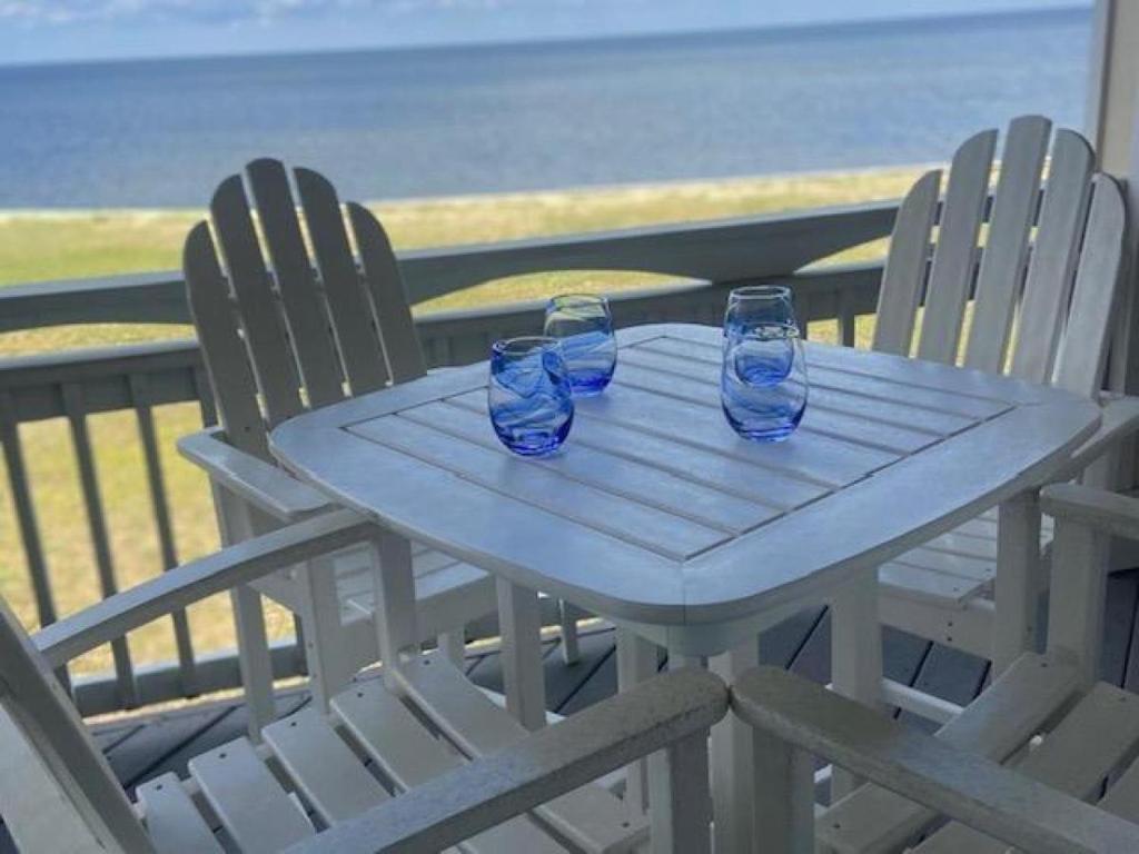 a table with two chairs and two blue glasses on it at RSR2A - Endless Sunsets in Rodanthe