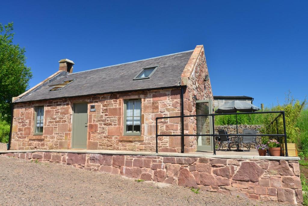an old stone house with a balcony on a stone wall at Scottish countryside Bothy in Arbroath