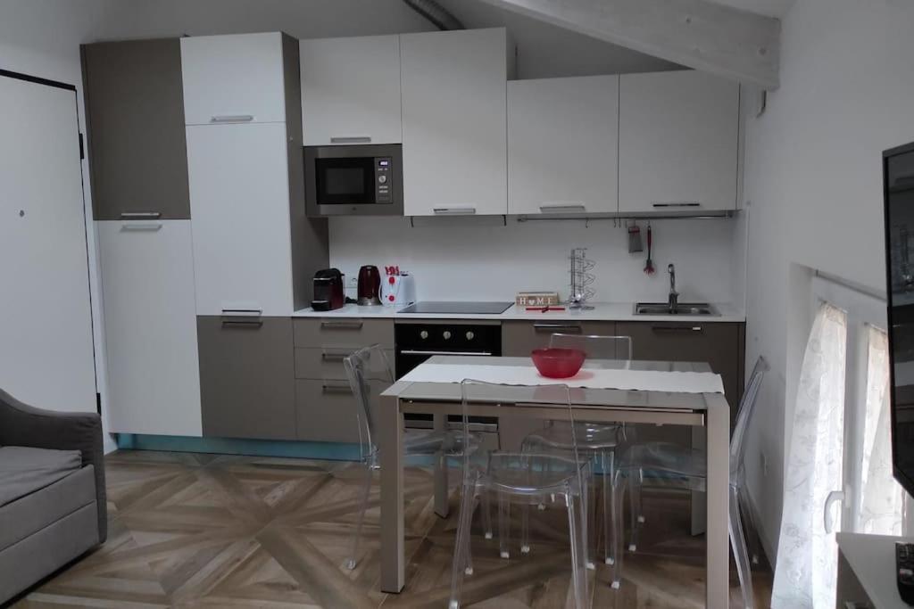 - une cuisine avec des placards blancs, une table et des chaises dans l'établissement Luminoso Bilocale zona Tibaldi Bocconi, à Milan