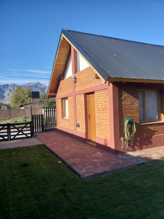 a small house with a large patio in front of it at La casita suereña in Esquel