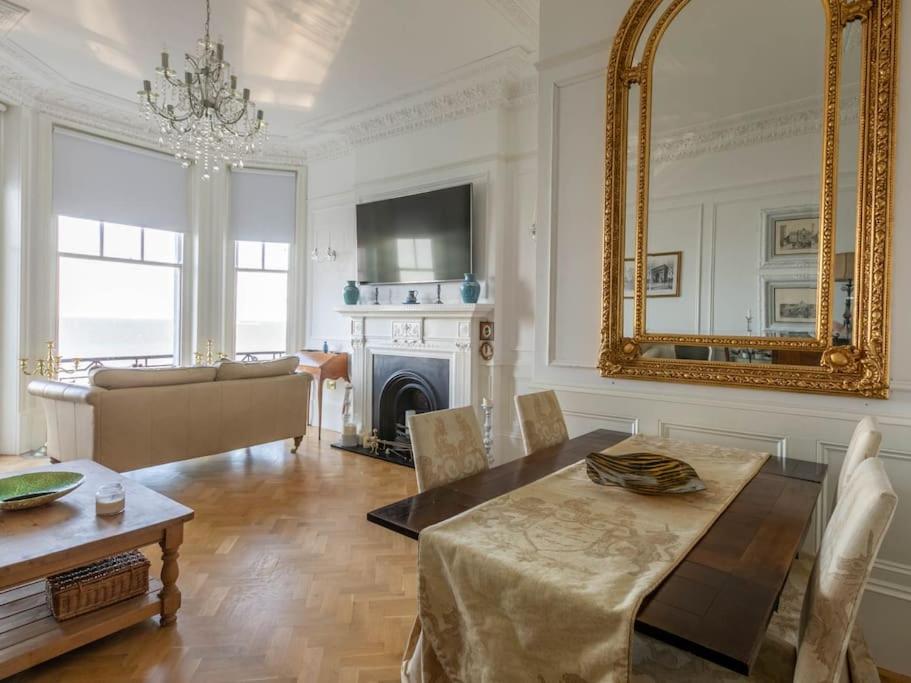 a living room with a table and a mirror at Walpole View - Balcony Apartment - Stunning Seafront Views -TV over bath -2mins beach in Kent