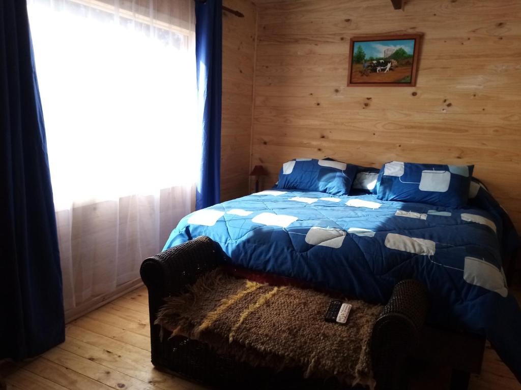 a bedroom with a bed and a couch and a window at Cabaña Felipe Kaluf in Constitución