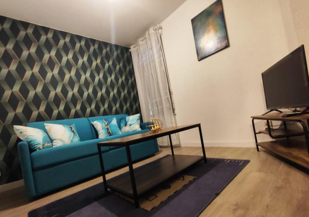 sala de estar con sofá azul y TV en Chazi, en Toulouse