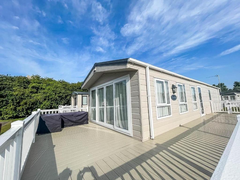 a home with a large deck with a house at Beautiful 8 Berth Caravan With Decking At Broadland Sands In Suffolk Ref 20017cv in Hopton on Sea