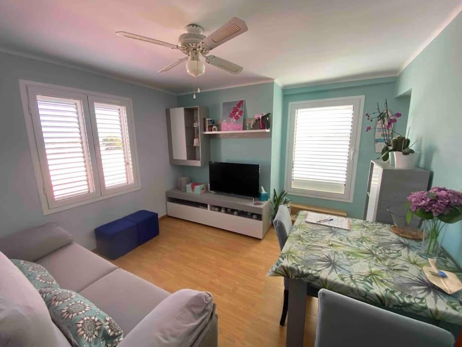 a living room with a couch and a table at Coqueto ático con vistas al mar y a la montaña Auto Check-in in Miami Platja