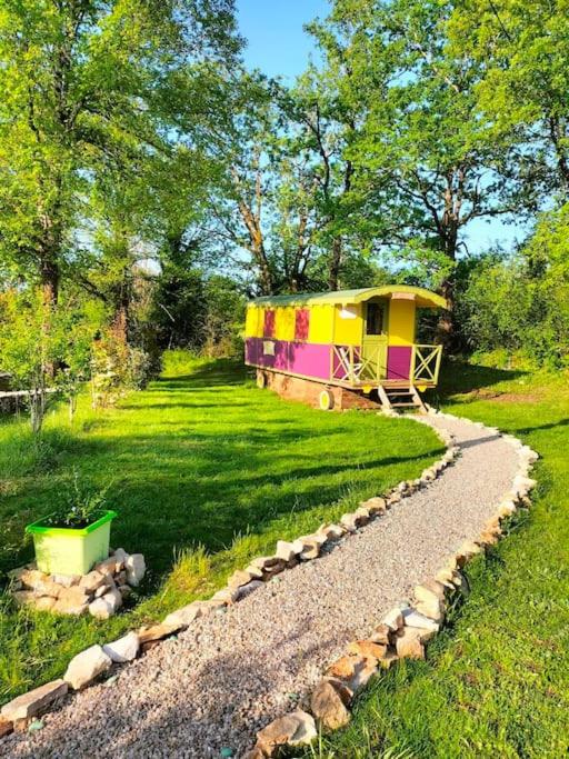 une cour de train avec une maison dans l'herbe dans l'établissement Jolie Roulotte, à Issendolus