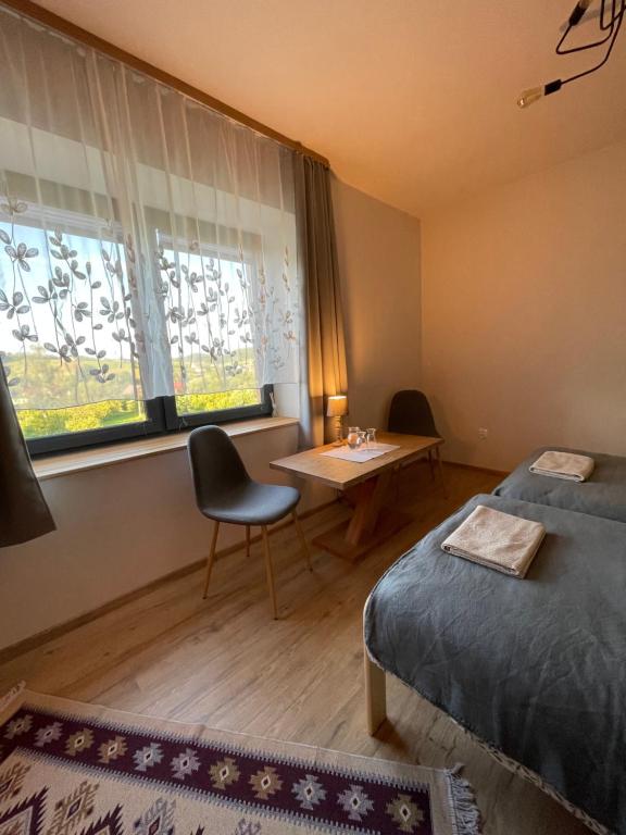 Zimmer mit einem Bett, einem Tisch und einem Fenster in der Unterkunft Przyszowa 441 in Przyszowa