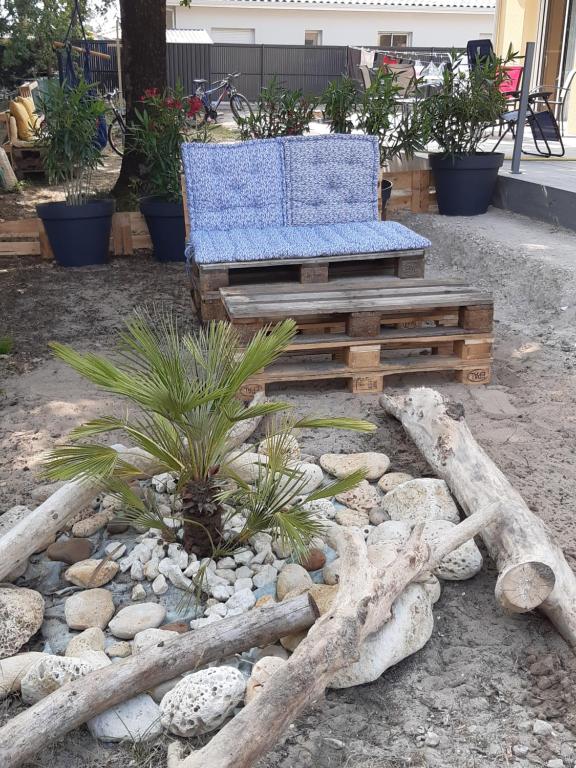 ein blauer Stuhl, der auf einer Bank im Hof sitzt in der Unterkunft CAP MONTA - Maison Neuve in Vendays-Montalivet