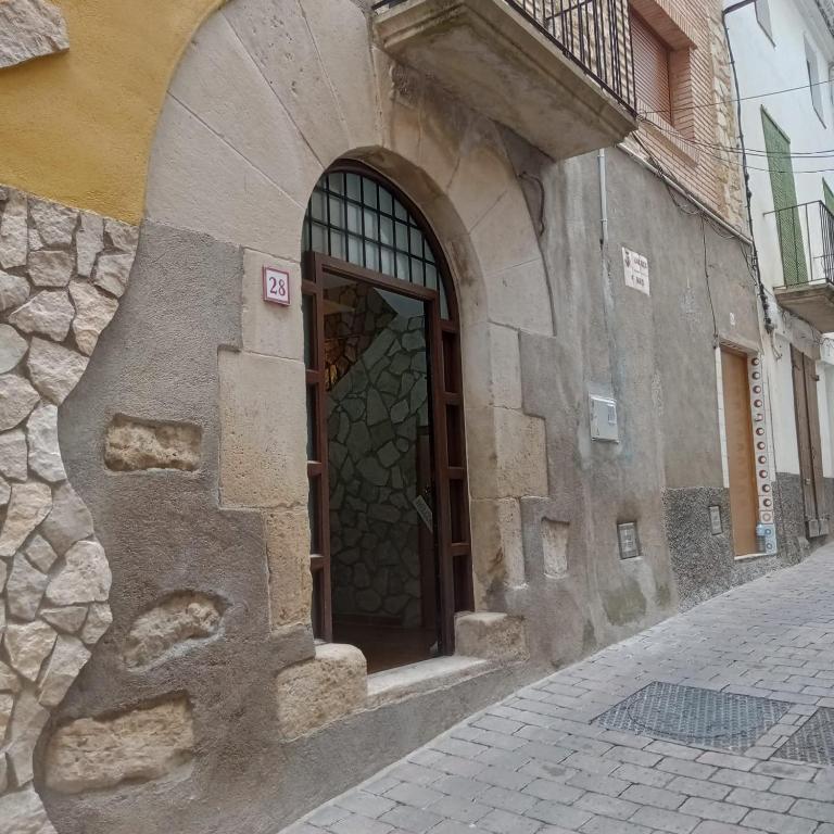 a stone building with a door on a street at Ca Serrulleta in Ascó