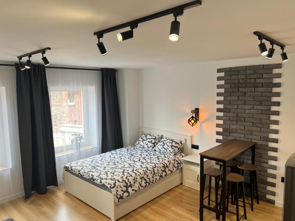a bedroom with a bed and a table and a desk at White and Black Apartments in Katowice