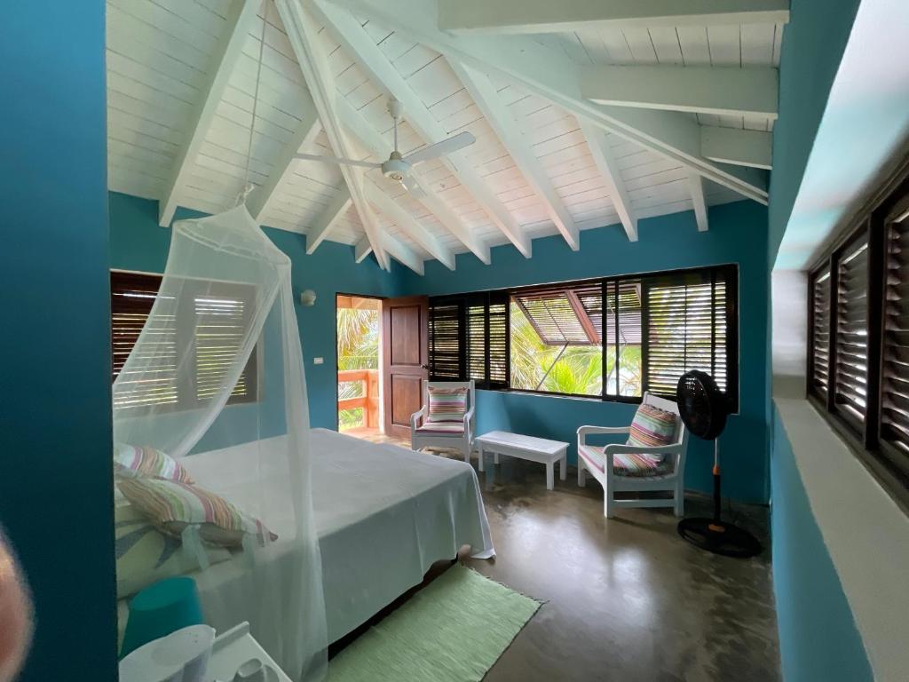 a bedroom with a white bed and a blue wall at Guestroom los gorgones in Las Galeras