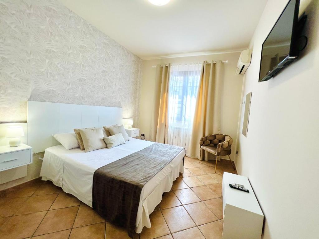 a hotel room with a bed and a television at Casa Aieddu in Terrasini