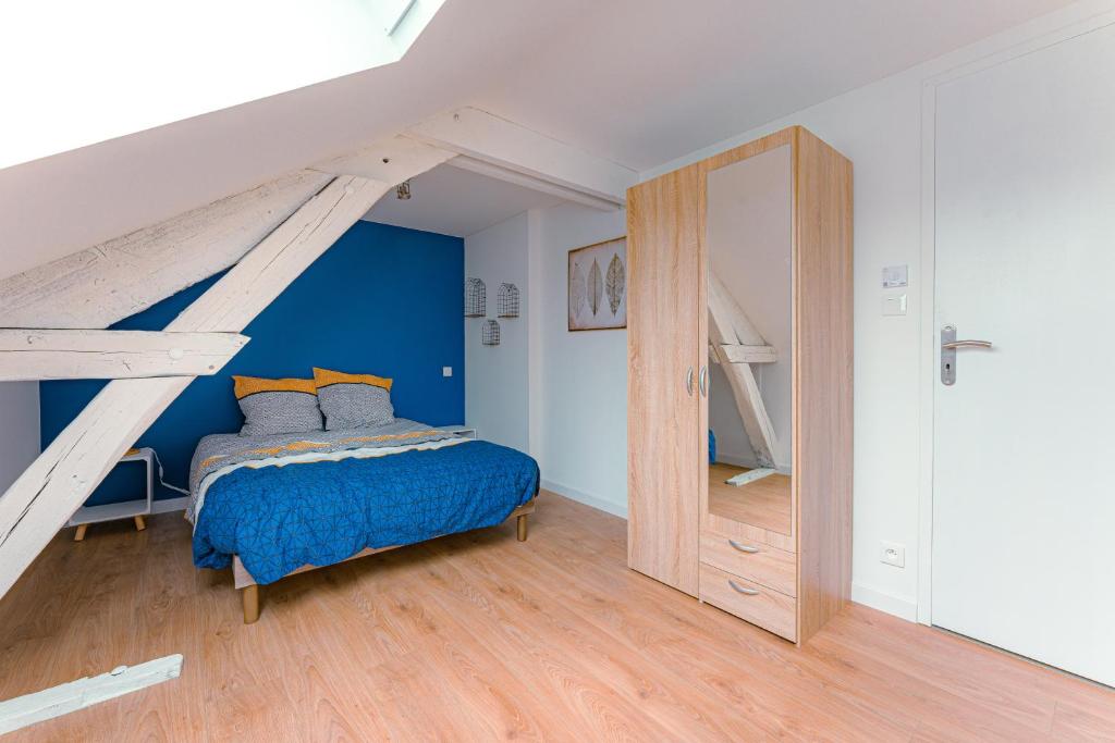 1 dormitorio con paredes azules, 1 cama y una escalera en Coeur de ville #H3 - WIFI et NETFLIX - Lave linge - Logement partagé - Chambre privée en Cholet