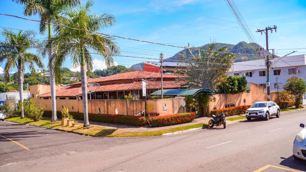 a house with a motorcycle parked on the side of a street at Pousada Sol de Verão in Barra do Garças