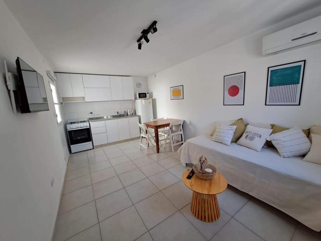 ein Wohnzimmer mit einem Sofa und einem Tisch in der Unterkunft Departamento Temporario La Plaza in Cordoba