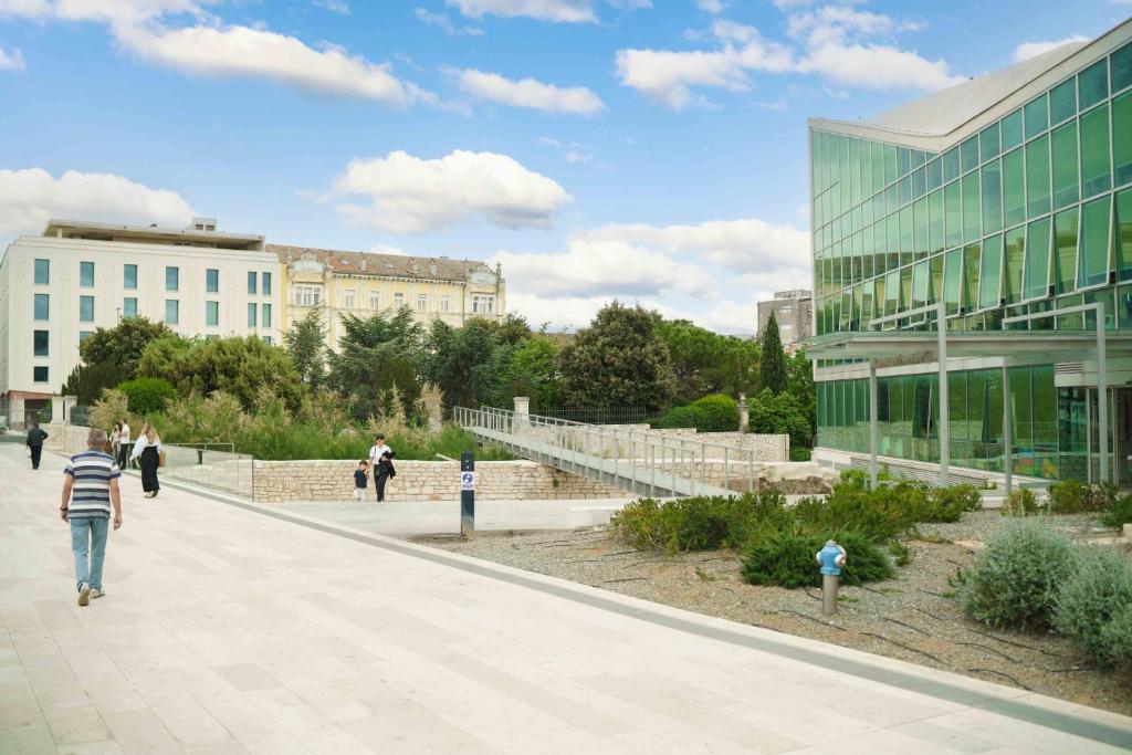 una persona caminando por una acera frente a un edificio en Hortensia, en Šibenik
